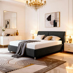 Modern Belsogno bed with a gray upholstered bed, chandelier, and abstract art.
