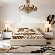 Modern bedroom with a chandelier, bed, and side tables.